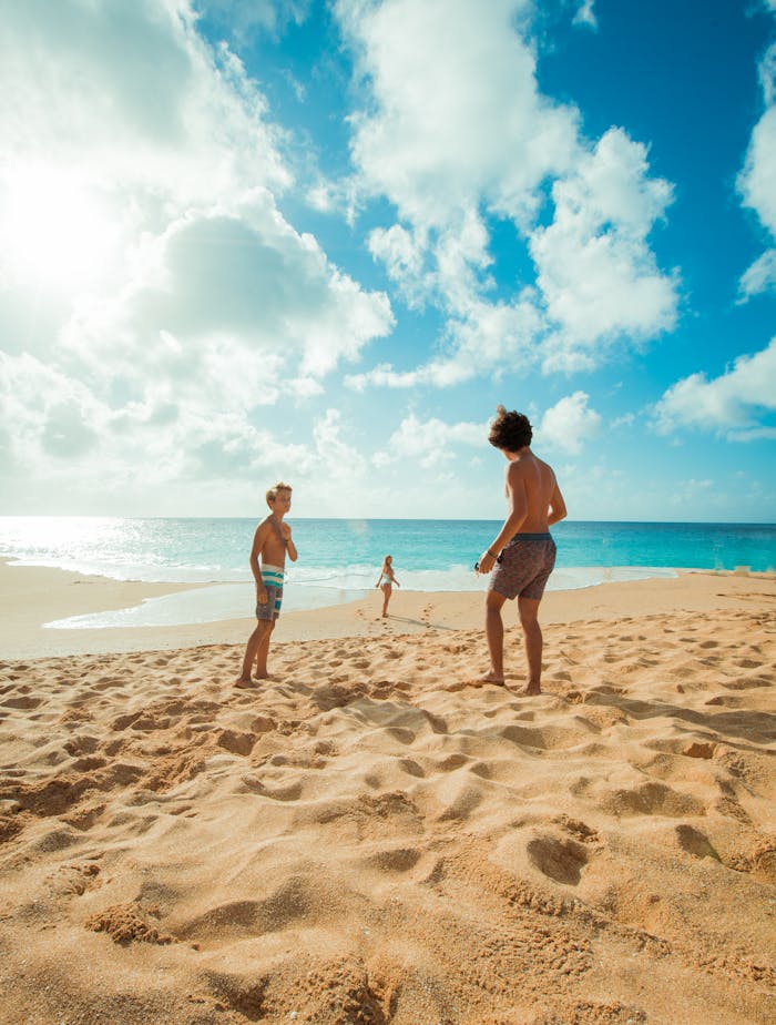 pexels-photo-1142984 Three children enjoy a sunny day playing on Waialua Beach, Hawaii, with clear skies and blue ocean waters.