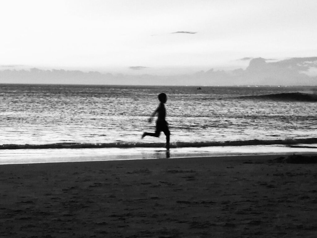 pexels-photo-30746181 A child's silhouette running along the beach at dusk, capturing a moment of freedom and nostalgia.